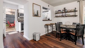 A dining area with a black table and chairs, a small kitchen with a microwave, and a view of the backyard through an open door. - 5 bedrooms. 2 Blocks to Barton Springs Pool, Zilker Park, Music, Food Trailers (Austin)