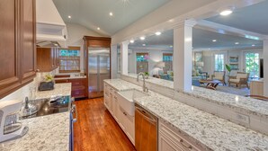 A modern kitchen with granite countertops, stainless steel appliances, and wooden cabinets. - SOUTHERNMOST BELLE~ Heated Pool, Gourmet Kitchen & Elegant Large Bedrooms! (Key West)