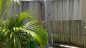 A fountain with water spraying upwards, surrounded by a concrete wall and a wooden fence. - Apartment in milionários beach, Ilheus - BA (Ilheus)
