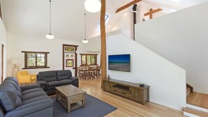 Ein geräumiges Wohnzimmer mit einer Couch, einem Couchtisch und einem Essbereich.