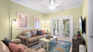 A living room with a beige sofa, a coffee table, and a starfish-patterned rug. - CASA DE VINO ~ Amazing Price for  Charming Townhouse with Pool & Tiki! (Key West)