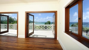 A spacious room with large windows and a view of the ocean. - Private Beachfront Home w/Pool, Solar, Banks Rd, Walk to Restaurants (Governors Harbour)