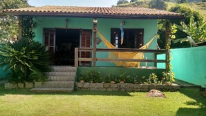 A green house with a tiled roof, a hammock, and a wooden gate. - House in front of the sea with a beautiful sunrise, deck for good fishing With WI- (Mangaratiba)