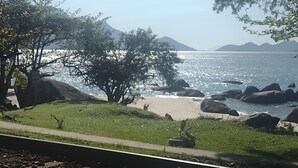 A coastal landscape with a beach, rocks, and trees. - House in front of the sea with a beautiful sunrise, deck for good fishing With WI- (Mangaratiba)