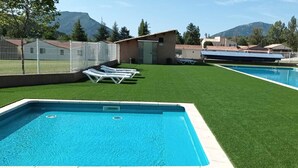 A rectangular swimming pool with a small circular drain in the center, surrounded by artificial green grass. - Superb holiday house in the natural beauty of the Gorges de Verdon (Castellane)