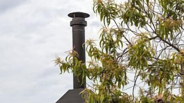 A stone building with a black wood-burning stove and potted plants in front. - Rural house (full rental) Palacio de Lérruz for 6 people (Lizoáin)