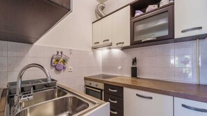 A modern kitchen with a stainless steel sink, a built-in oven, and a microwave. - Apartment Juranic with spacious Terrace (Krk)