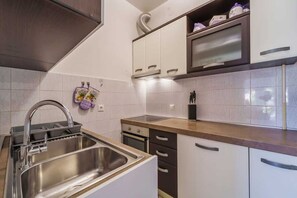 A modern kitchen with a stainless steel sink, a built-in oven, and a microwave. - Apartment Juranic with spacious Terrace (Krk)