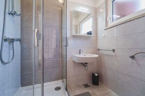 A modern bathroom with a glass shower enclosure, a sink, and a mirror. - Apartment Juranic with spacious Terrace (Krk)