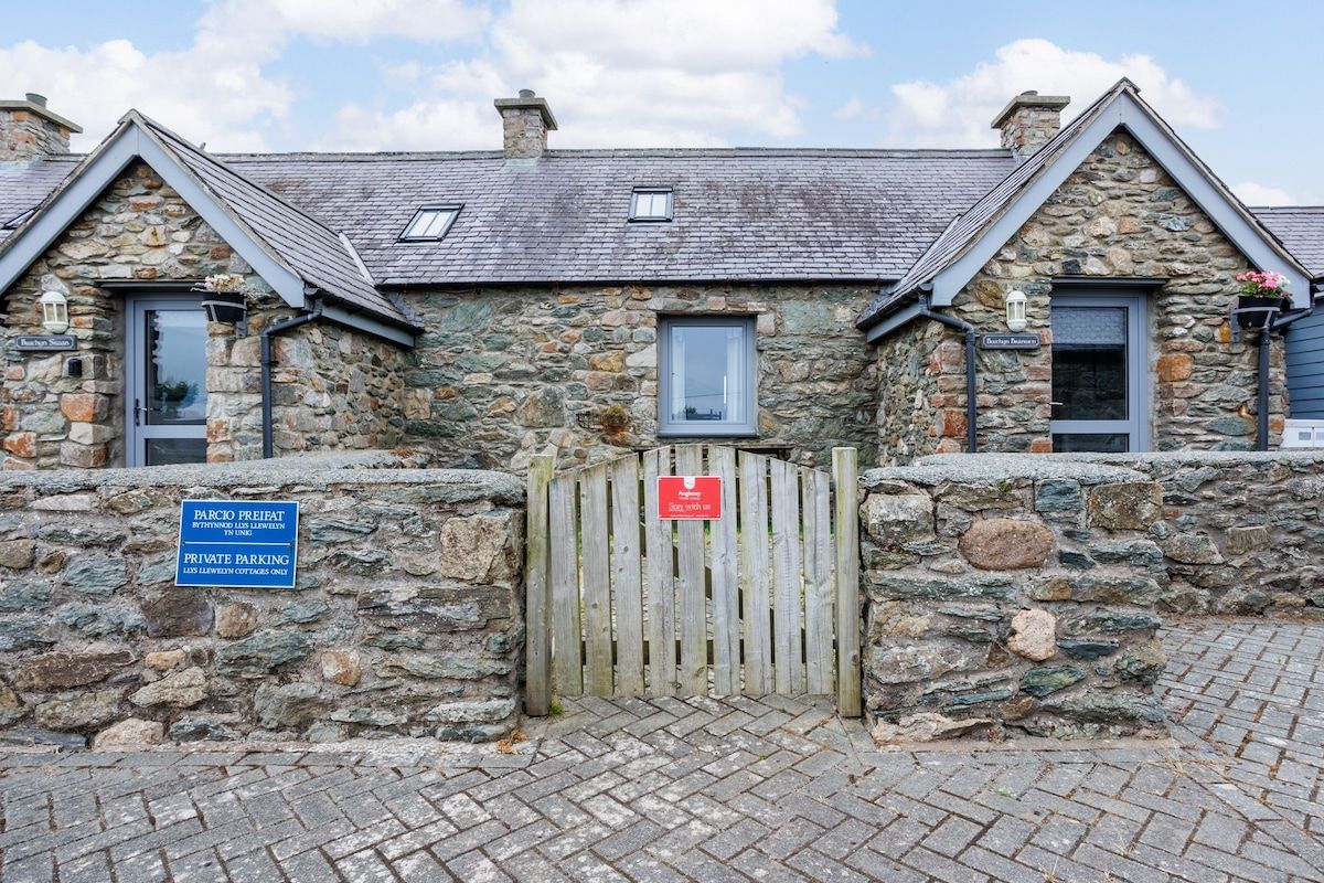 A stone building with a wooden gate, a sign indicating private parking, and a small window.