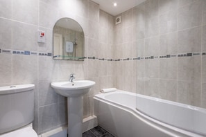 A bathroom with a toilet, sink, and bathtub. - Bay View: A two bed, pet-friendly holiday apartment in Rhosneigr (Rhosneigr)
