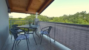 A balcony with a wooden ceiling, a table, and four chairs. - Apartment Cindrić 2 on the 2nd floor (Gabonjin)