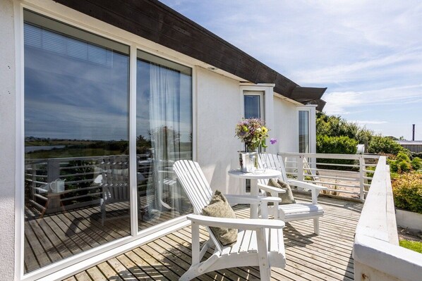 View from the lake terrace back into the bright open-plan living area through patio doors, holiday apartment in Llanfaelog, Anglesey