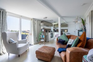 Cosy lounge with leather sofa, wood burner and flat-screen TV, couples retreat with hot tub in Llanfaelog, Anglesey - Bryn Bach: Pet-friendly cottage on the Isle of Anglesey (Ty Croes)