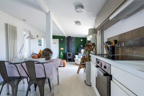 A modern kitchen with a dining area, a built-in stove, and a fireplace.