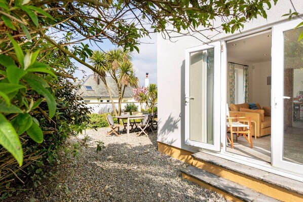 A modern house with a patio area, a dining table, and a sofa.