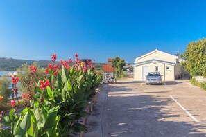 Park your car in a serene setting surrounded by lush greenery and a scenic hillside view.