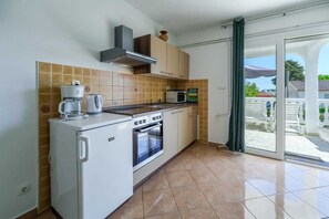 Une cuisine compacte Ă©quipĂ©e dâun four, dâun micro-ondes et dâune machine Ă cafĂ© intĂ©grĂ©s.