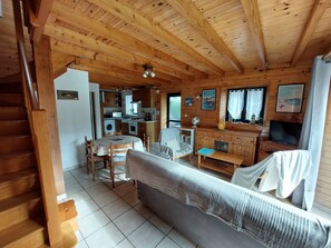 L'intérieur d'une cabane en bois comprend un coin repas, une cuisine et un espace de vie.