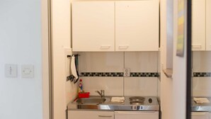 A compact kitchen with a sink, stove, and dishwasher.