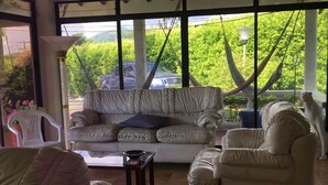 A sunlit room with a sofa, chairs, and a table. - Villa for rent in Cerritos Pereira (Pereira)