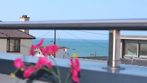 Un balcone con vista sul mare e sugli edifici.