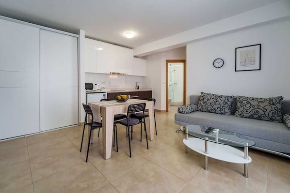 A compact living space with a kitchenette, dining area, and a sofa. - Apartment Nino 3 on the first floor (Malinska)