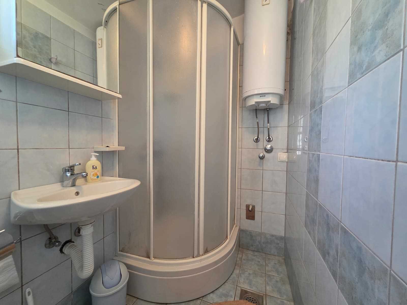 A bathroom with a shower, sink, and toilet.