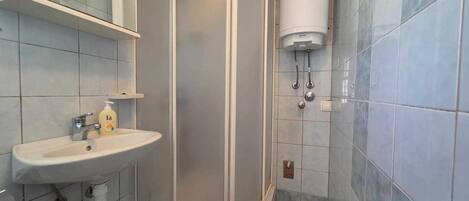 A bathroom with a shower, sink, and toilet.