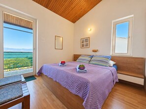 Ein Schlafzimmer mit einem Bett, einem Schreibtisch und Meerblick.