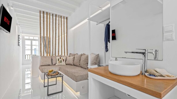 Une salle de bain moderne avec un lavabo blanc, un miroir et un plan de toilette en bois.