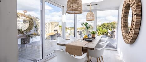 A dining area with a table, chairs, and a view of the outdoors.