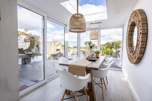 A dining area with a table, chairs, and a view of the outdoors. - Hafan: Pet-friendly beach-front holiday cottage in Rhosneigr (Rhosneigr)