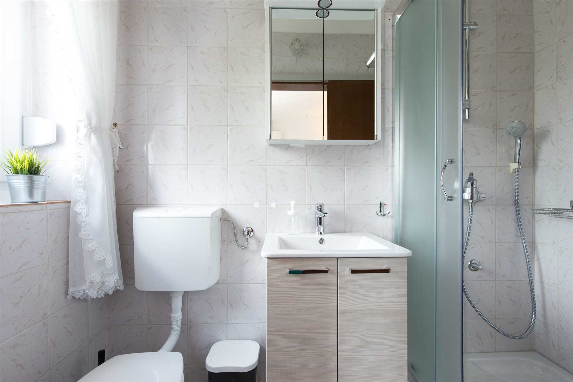 A modern bathroom with a toilet, sink, and shower.