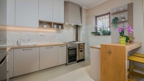 Une cuisine moderne avec des armoires blanches, un four encastré et un plan de travail en bois.