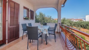 Un balcon avec une table et des chaises, une vue sur les environs et une balustrade.