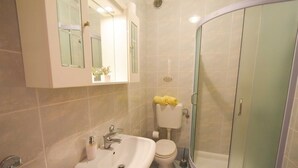 Une salle de bain équipée d’un lavabo, de toilettes et d’une douche à parois de verre.