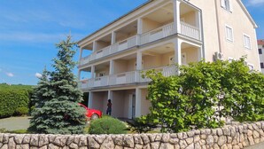 Un bâtiment à deux étages, doté d’un balcon au rez-de-chaussée et d’une cheminée sur le toit.
