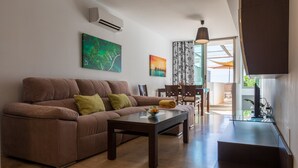 A modern living room with a brown sofa, a glass coffee table, and a dining area with a table and chairs. - Casa Jurinea Beach with sea view and pool (Carboneras)