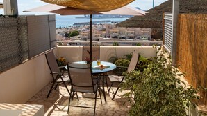 A balcony with a table, chairs, and a view of the city and sea. - Casa Jurinea Beach with sea view and pool (Carboneras)