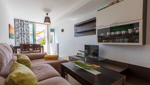 A modern living room with a sofa, a coffee table, a TV, and a bookshelf. - Casa Jurinea Beach with sea view and pool (Carboneras)