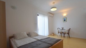 A bedroom with a bed, a desk, and a chair. - Studio Vera with balcony (Malinska)