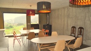 A dining area with a large table, chairs, and a view of a building and landscape through a window. - Rural apartment Casona la Sierra for 3 people (Cudillero)