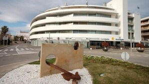 A modern building with a circular design, featuring multiple balconies and a restaurant named "Cafeteria." - BEACH APARTMENT 3 in TOSSA DE MAR (Tossa de Mar)