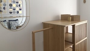 A minimalist room with a wooden desk, a wall-mounted mirror, and a decorative wall piece. - BEACH APARTMENT 3 in TOSSA DE MAR (Tossa de Mar)