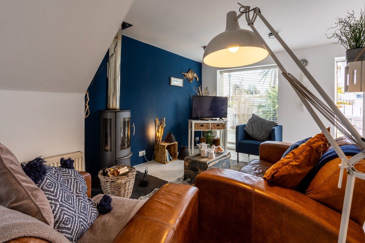 A living room with a fireplace, sofa, and television.