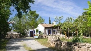 A rural road leading to a white house with a tiled roof, surrounded by greenery and stone walls. - Self catering Cortijo Algabia for 4 people (Alhendín)