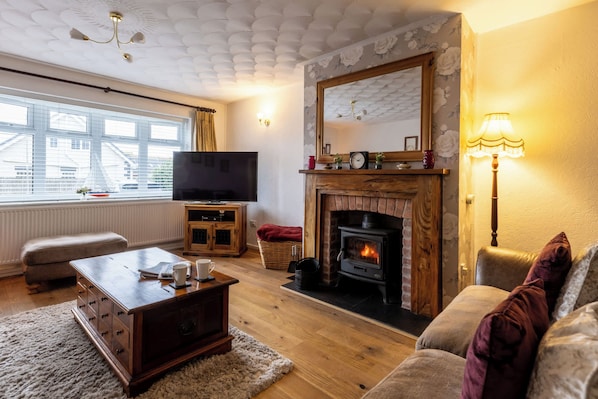 A cozy living room with a fireplace, a television, and a comfortable seating area.