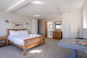 Une chambre à coucher avec un lit en bois, une table de chevet et un bureau avec une chaise.