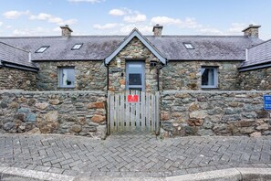 Welcoming front door of Bwthyn Siwan, charming two-bedroom stone holiday cottage in historic Aberffraw, Anglesey - Bwthyn Siwan: Two bedroom, pet-friendly holiday cottage (Ty Croes)